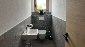 A narrow bathroom with a window, a toilet, and a sink. - Studler-Eck - Holidays at the most beautiful place in the Tyrol (Oberperfuss)