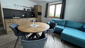 Un espace de vie moderne comprenant un coin repas, un canapé et une cuisine.