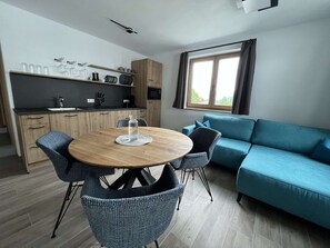 Ein stilvoller Wohnbereich mit Essplatz, einer Couch und einer Küche.