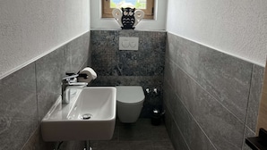 Une salle de bain avec un lavabo, des toilettes et une fenêtre donnant sur un beau paysage.