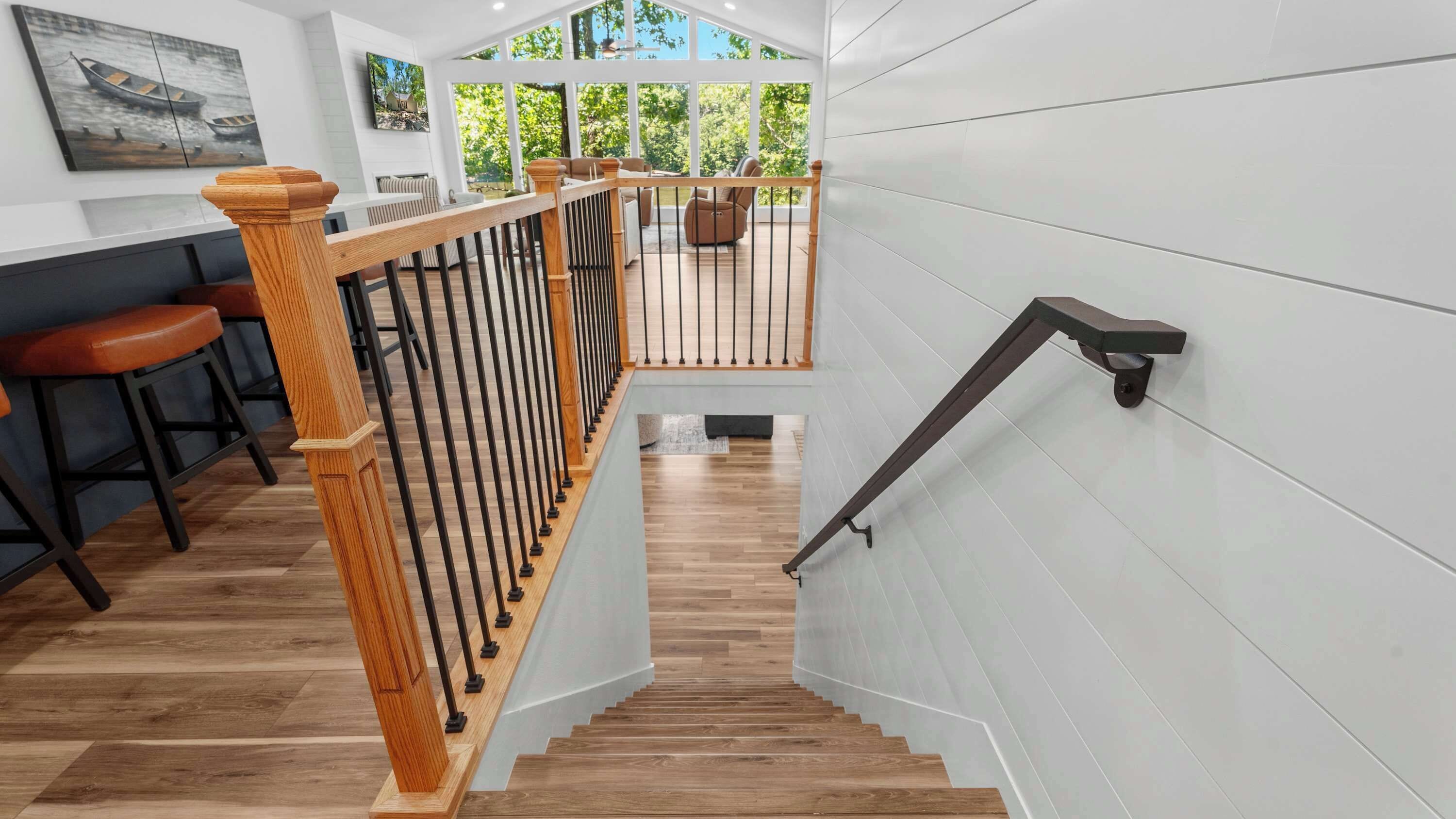 A staircase with wooden railings leading to a balcony with a view of trees.
