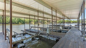 Une jetée abritée, dotée de bancs et de tables en bois, et entourée d’eau.