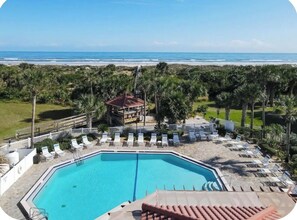 A pool with lounge chairs, a view of the beach, and palm trees. - Sun&Sand Oasis - Beach Front - 2/2 Condo - Next to Heated Pool - Ground Floor (St. Augustine)