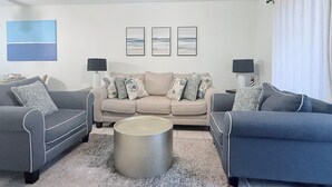 A living room with a sofa set, a coffee table, and a ceiling fan. - Sun&Sand Oasis - Beach Front - 2/2 Condo - Next to Heated Pool - Ground Floor (St. Augustine)