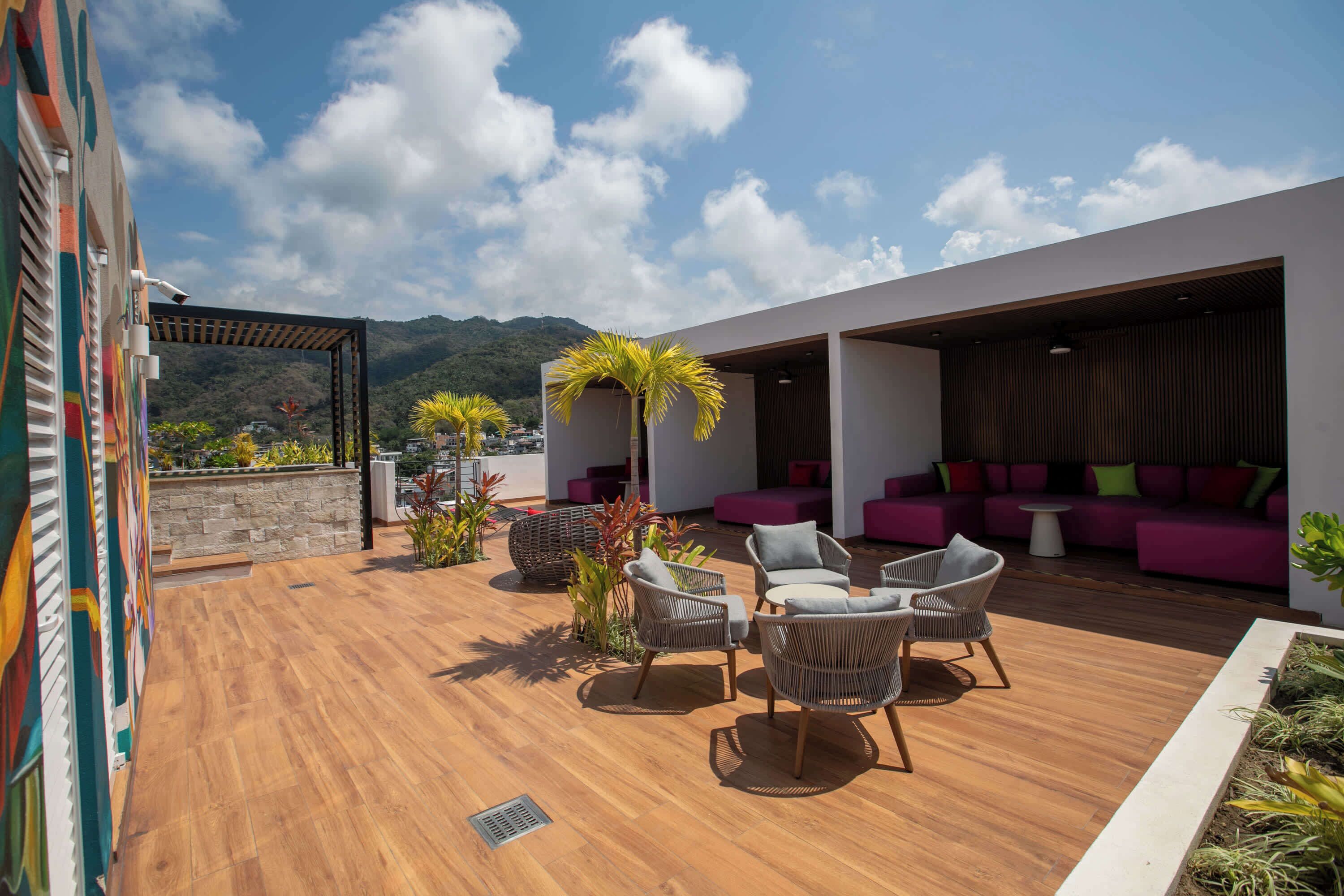 Une terrasse sur le toit avec des sièges extérieurs, une pergola et une vue sur les montagnes.
