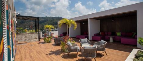 Une terrasse sur le toit avec des sièges extérieurs, une pergola et une vue sur les montagnes.