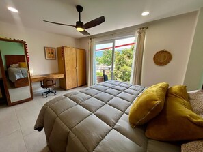 A bedroom with a bed, a desk, a chair, a wardrobe, and a ceiling fan. - Casa Lluvia Retreat • Rooftop Infinity Pool (Puerto Vallarta)
