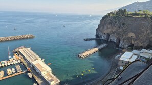 A coastal marina with boats docked, a rocky cliff, and a clear view of the sea. - Unit 8 - Bright Apartment Near the Beach & Downtown (Piano di Sorrento)