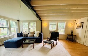 Ein Wohnzimmer mit Ecksofa, Couchtisch, Sessel und Heizkörper.