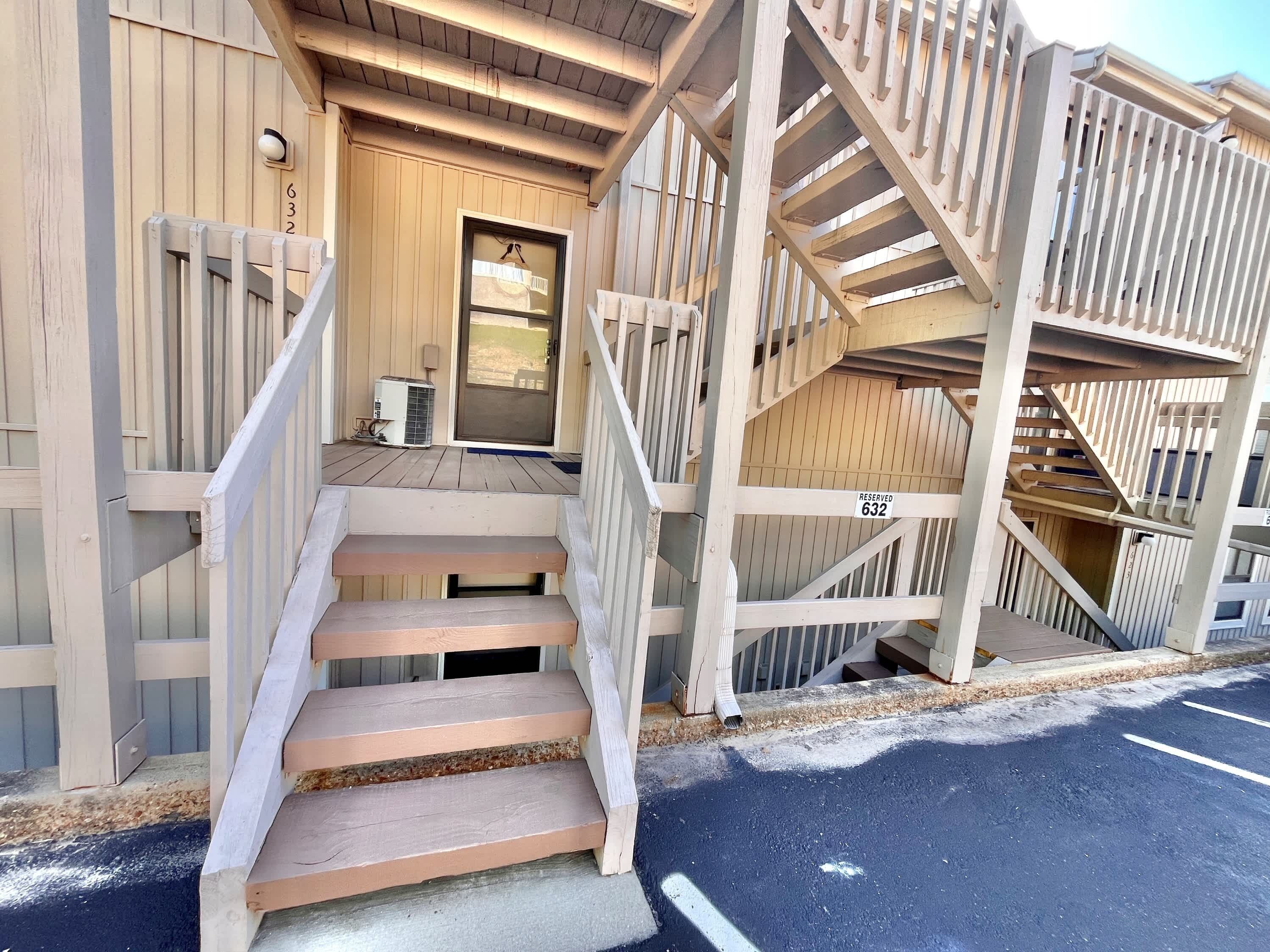 A wooden building with a porch, a set of stairs, and a door marked 'RESERVED 632'.