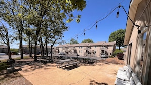 En innergård med picknickbord, en brandpost och en byggnad med en trappa.