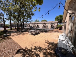 Ein Innenhof mit Picknicktischen, einem Hydranten und einem Gebäude mit einer Treppe.