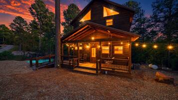 Porch swings, pine trees, a pool, and that sky — this cabin is the whole package.