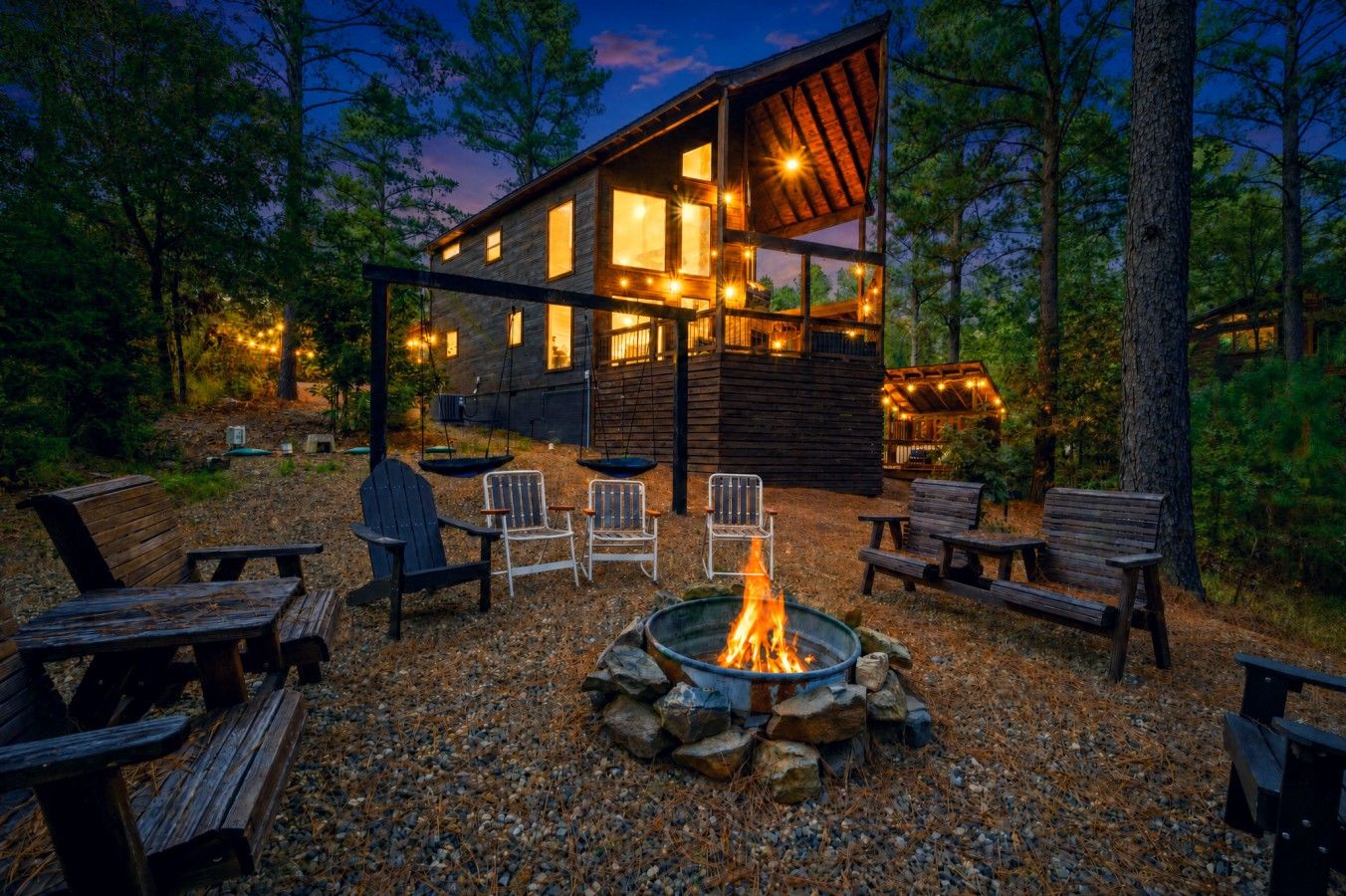 Eine Holzhütte mit Feuerschale und Sitzgelegenheit im Freien.
