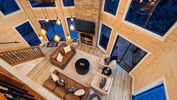A spacious living area with a fireplace, multiple seating options, and large windows.