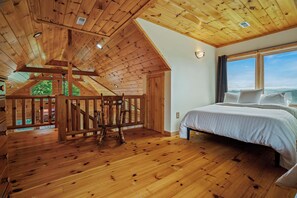 A bedroom with a wooden ceiling, a bed, and a view through a window. - Wooded Cabin Charm, Lake Views, Hot Tub, Fire pit (New Tazewell)