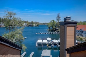 A waterfront property with docked boats, a pier, and a view of the surrounding forest.