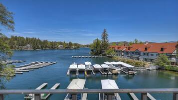 A lakeside view with docked boats, a pier, and buildings with red roofs.