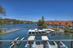 A lakeside view with docked boats, a pier, and buildings with red roofs.
