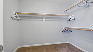 A corner of a room with a brown carpet, white walls, and a white door.