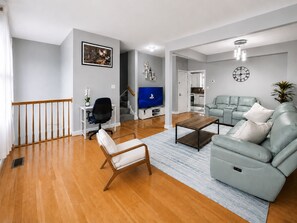 Una sala de estar moderna con sofá, mesa de centro y televisor.