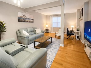 A modern living room with a sofa, coffee table, and a television.