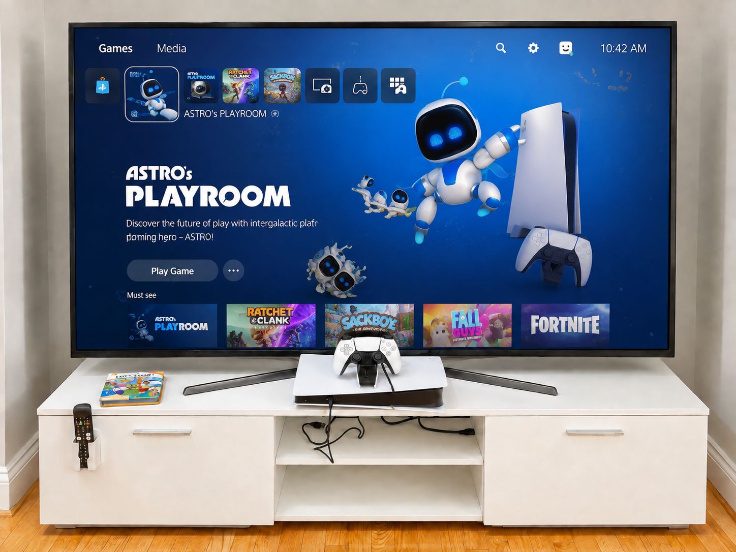 En tv-skärm som visar ett gränssnitt från ett tv-spel, med en robotkaraktär och en PlayStation-kontroller.