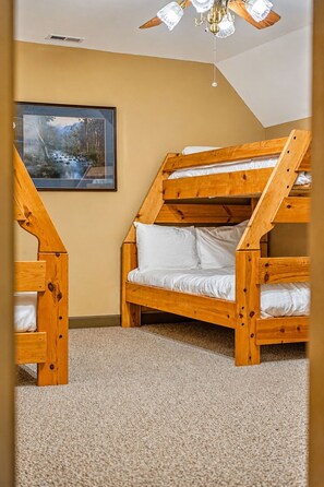 A room with a bunk bed, a ceiling fan, and a framed picture on the wall. - Lakeside Haven: Boat Dock, Ramp, Games, & MORE! (Sevierville)