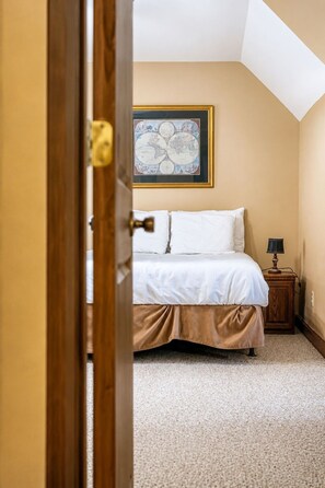 A bedroom with a bed, a nightstand, a lamp, and a framed map on the wall. - Lakeside Haven: Boat Dock, Ramp, Games, & MORE! (Sevierville)