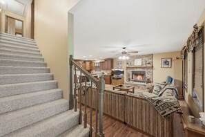 A multi-level home with a staircase, a living room with a fireplace, and a kitchen area. - Lakeside Haven: Boat Dock, Ramp, Games, & MORE! (Sevierville)
