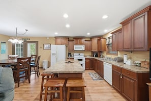 A spacious kitchen with wooden cabinets, a granite countertop, and a central island. - Lakeside Haven: Boat Dock, Ramp, Games, & MORE! (Sevierville)
