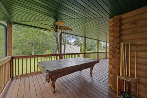 A wooden deck with a pool table and cue rack, a ceiling fan, and a view of a house and trees. - Lakeside Haven: Boat Dock, Ramp, Games, & MORE! (Sevierville)