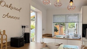 Uma cozinha moderna com bancada de madeira, forno embutido, pia e janela com vista para o exterior.