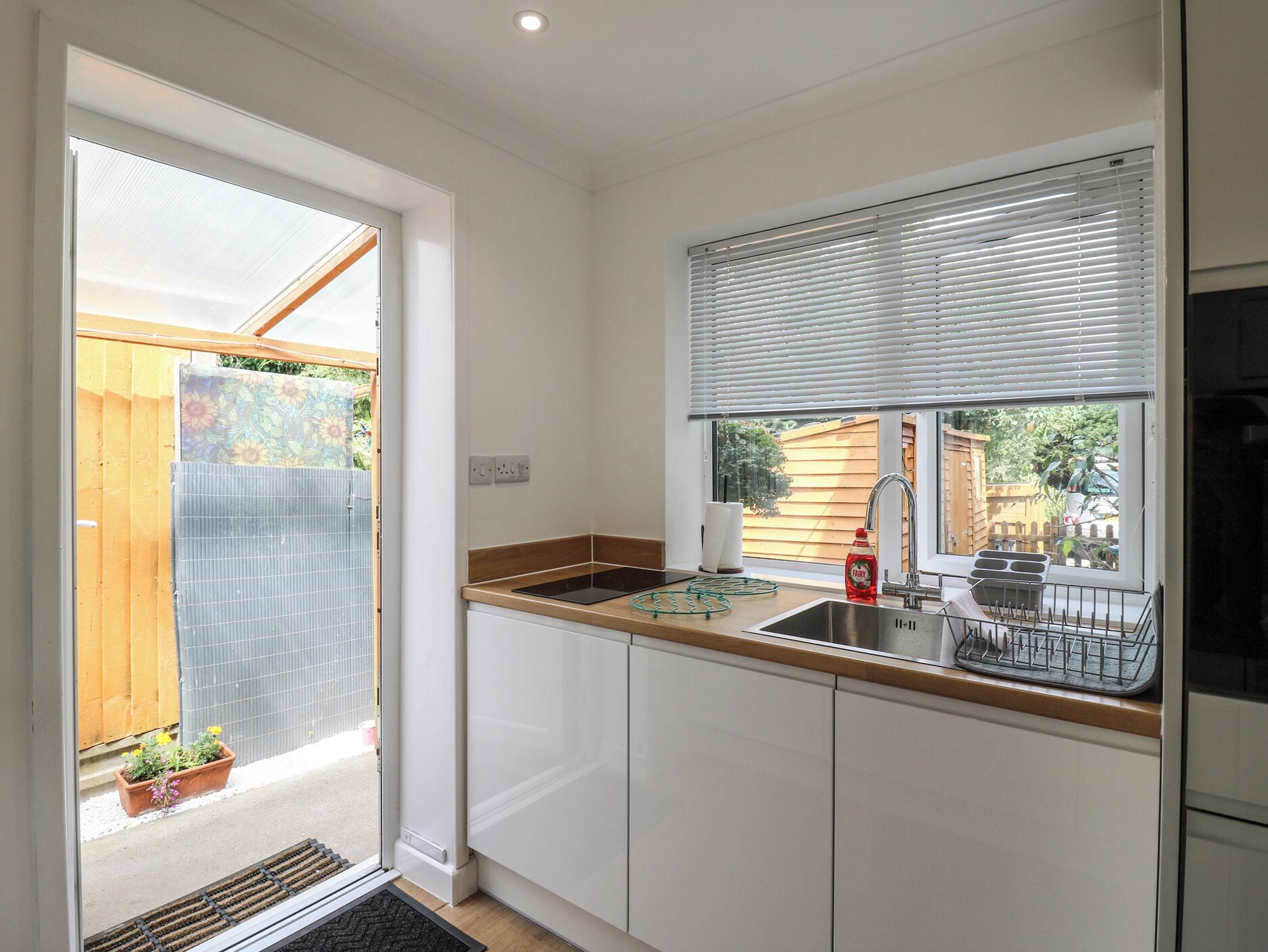 A kitchen with a window, sink, and a view of the outside.