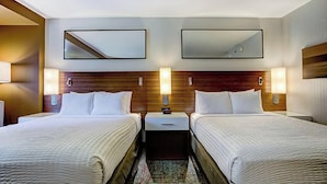 A hotel room with two beds, nightstands, wall-mounted lamps, and a mirror. - The Point Casino and Hotel (Kingston)