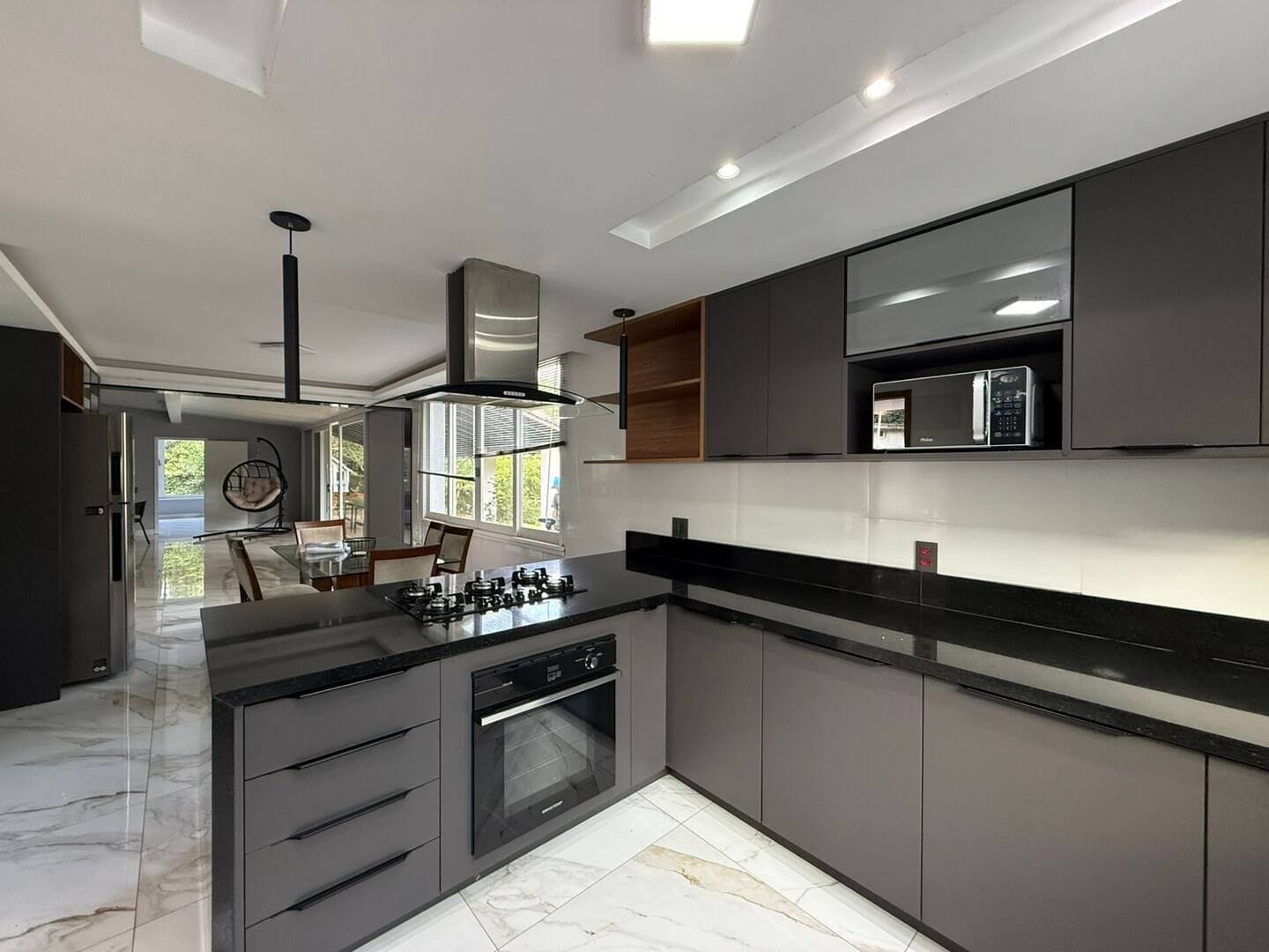 A modern kitchen with a central island, built-in oven, and microwave.