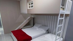 Ett sovrum med en våningssäng, ett litet fönster och en inbyggd stege.