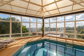 A pool area with a view of the surrounding landscape. - Casa de Campo com Lago Piscinas Jacuzzi e Sauna (Atibaia)