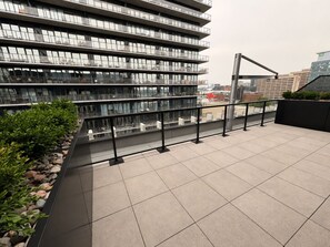 A modern building with multiple floors, large windows, and a balcony with a metal railing. - 1 BR Industrial-Chic Penthouse Loft | City Views (Halifax)