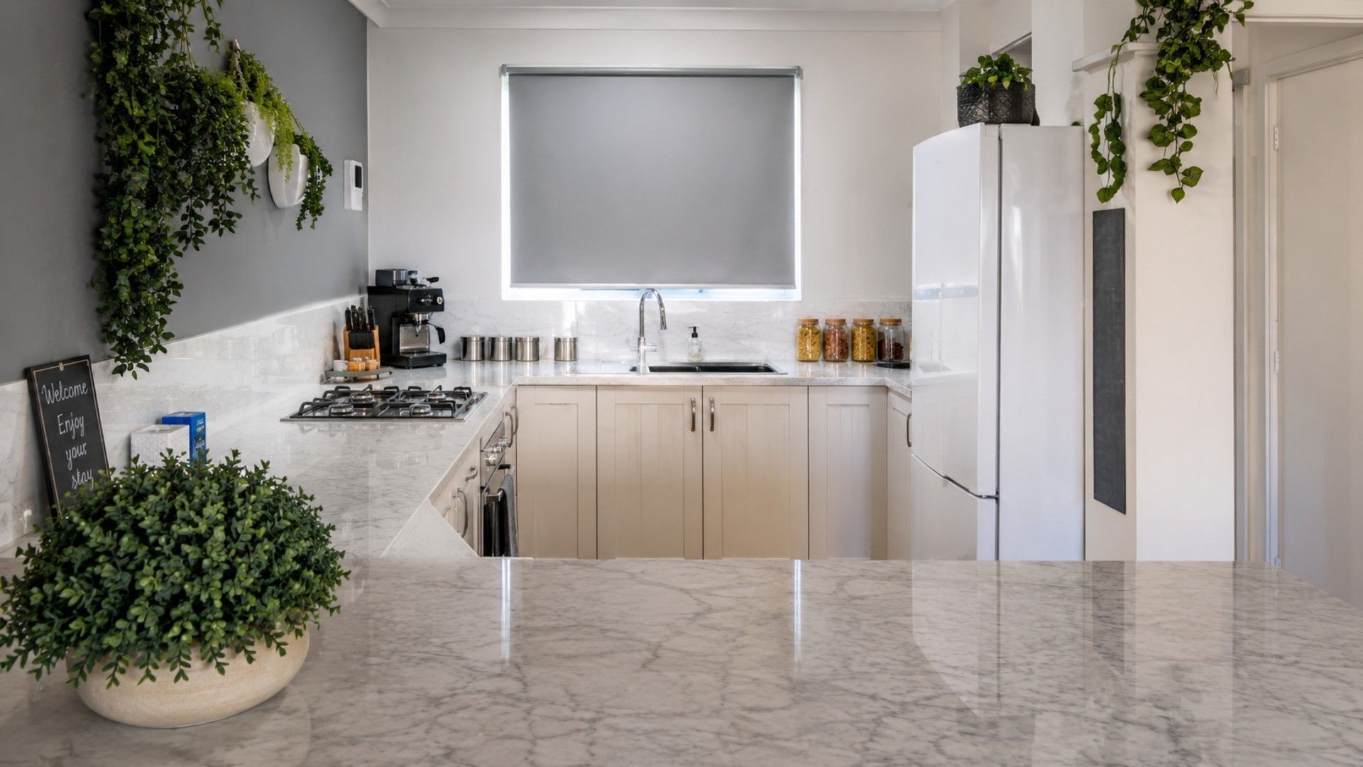 A modern kitchen with a built-in oven, a coffee machine, and a sink.