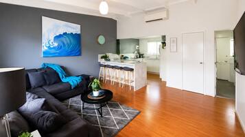 A modern living room with a sofa, a coffee table, and a painting on the wall.