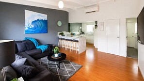 Una sala de estar moderna con un sofá, una mesa de centro y un cuadro en la pared.