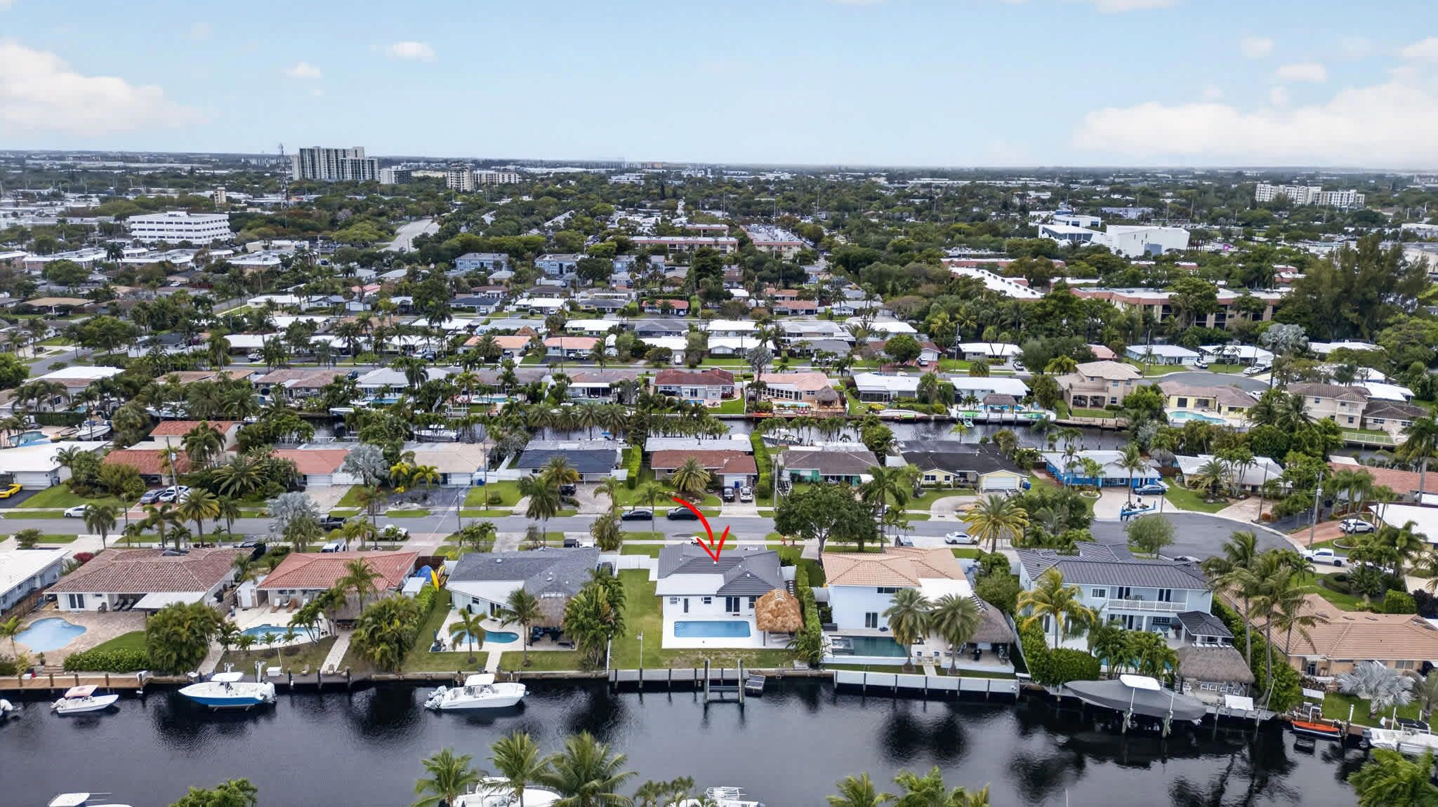 A residential area with houses, a marina, and a clear sky.
