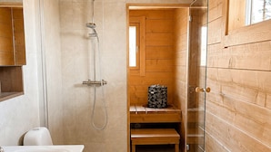 Une salle de bain moderne avec un intérieur en bois, une baignoire, des toilettes et une douche.