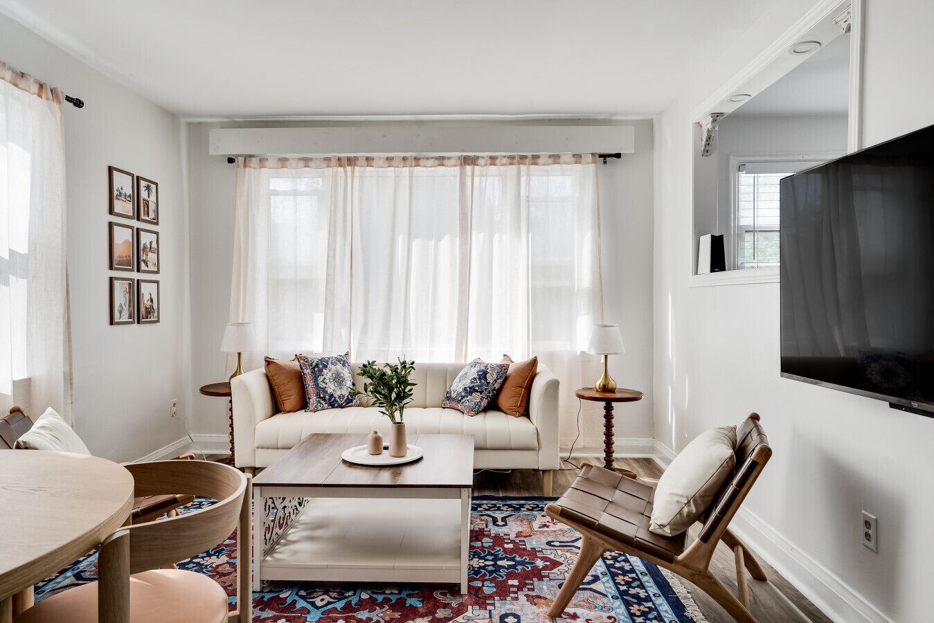 A living room with a sofa, coffee table, and a TV mounted on the wall.