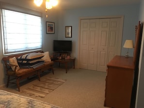 A room with a sofa, television, and a closed door. - Homey 3-bedroom condo in cul-de-sac in Bethany Beach golf community (Bethany Beach)