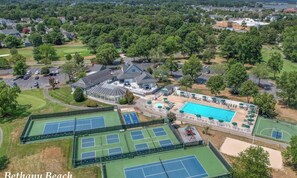Ein Wohnhaus mit Tennisplatz, Schwimmbad und einer großen Villa mit Garage.