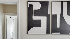 Un interior modern amb una cadira de pedra, un tapet i una obra d'art abstracta a la paret.