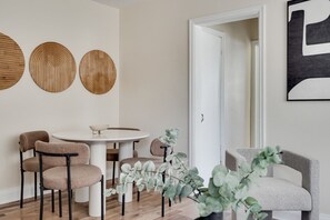 A dining area with a round table, four chairs, and three wall-mounted circular decorations. - Bright 1BR Near Queen’s, KGH & Waterfront! (Kingston)