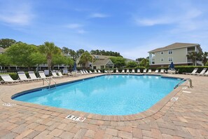 A rectangular swimming pool with a 5 ft depth marker, surrounded by lounge chairs and a brick deck. - Coastal Comfort Pet Friendly Barefoot Resort Villa (North Myrtle Beach)